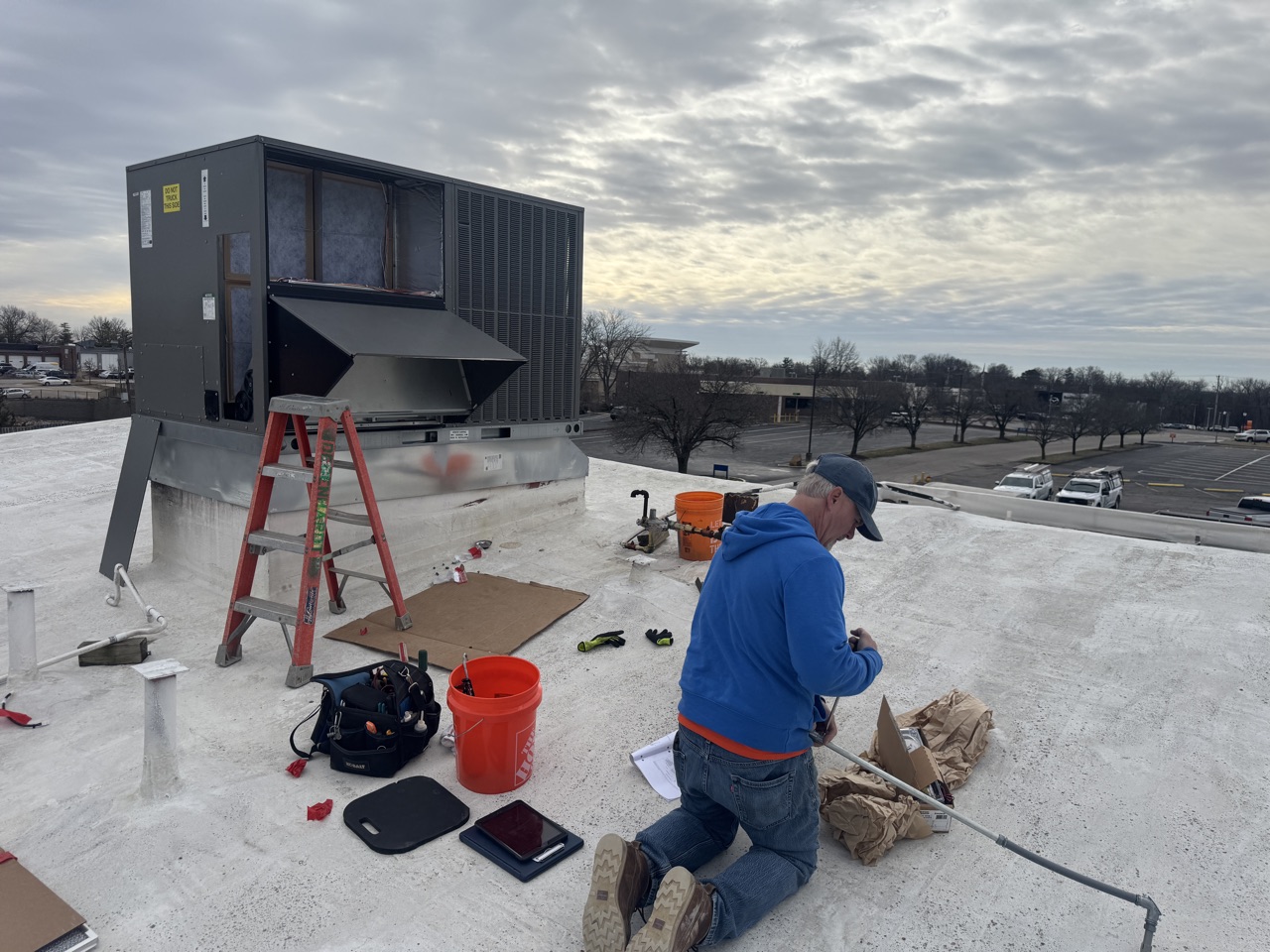 A Degenhardt technician setting a Rheem rooftop unit on a commercial roof